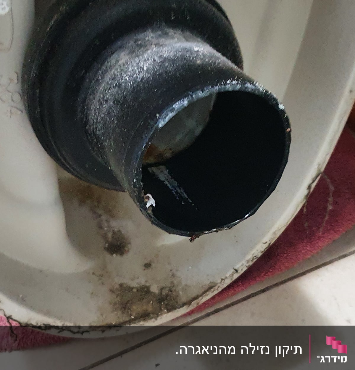 חיבור צינור שחור לאסלה על מגבת אדומה